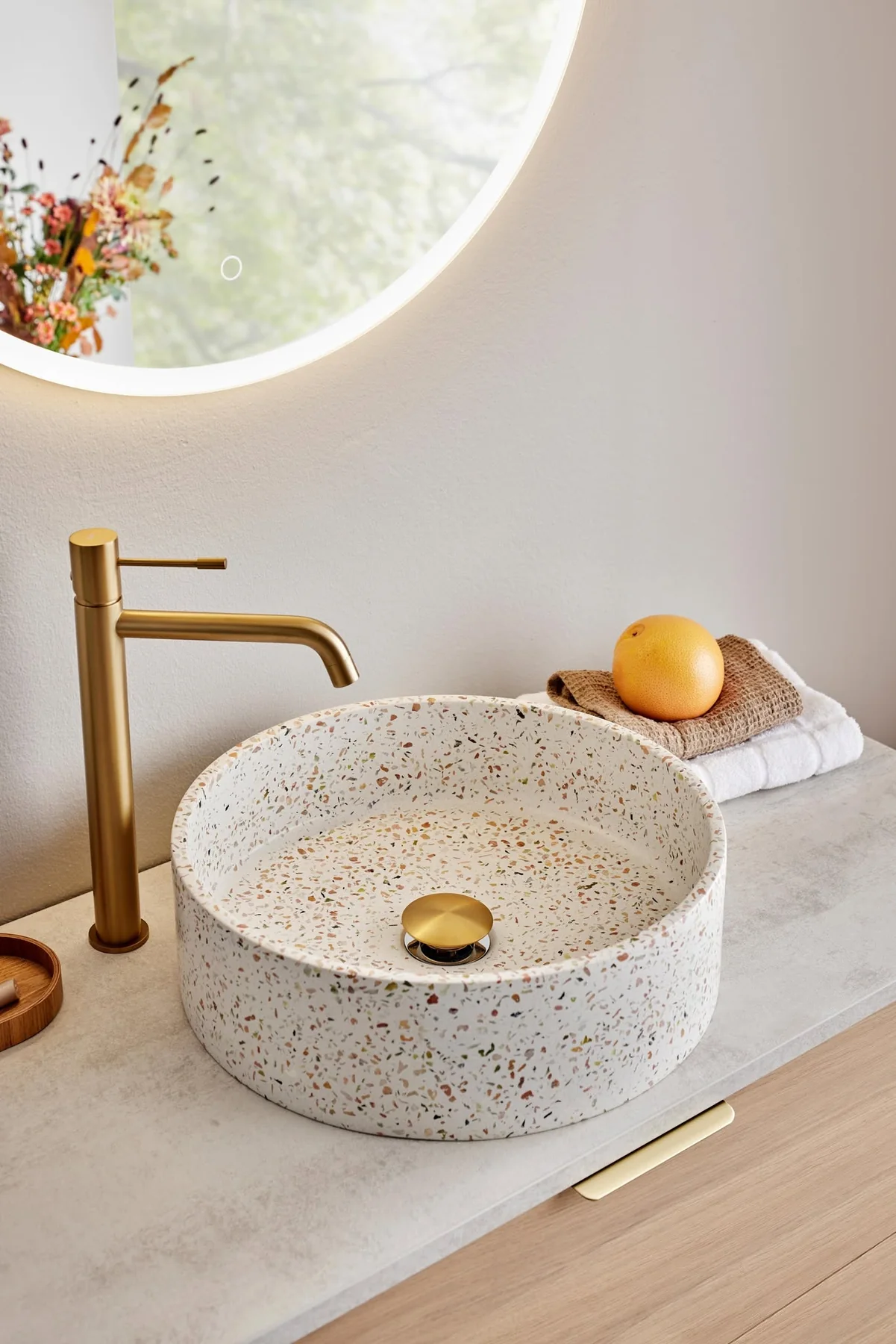 Gullfarget armatur med terrazzo-servant